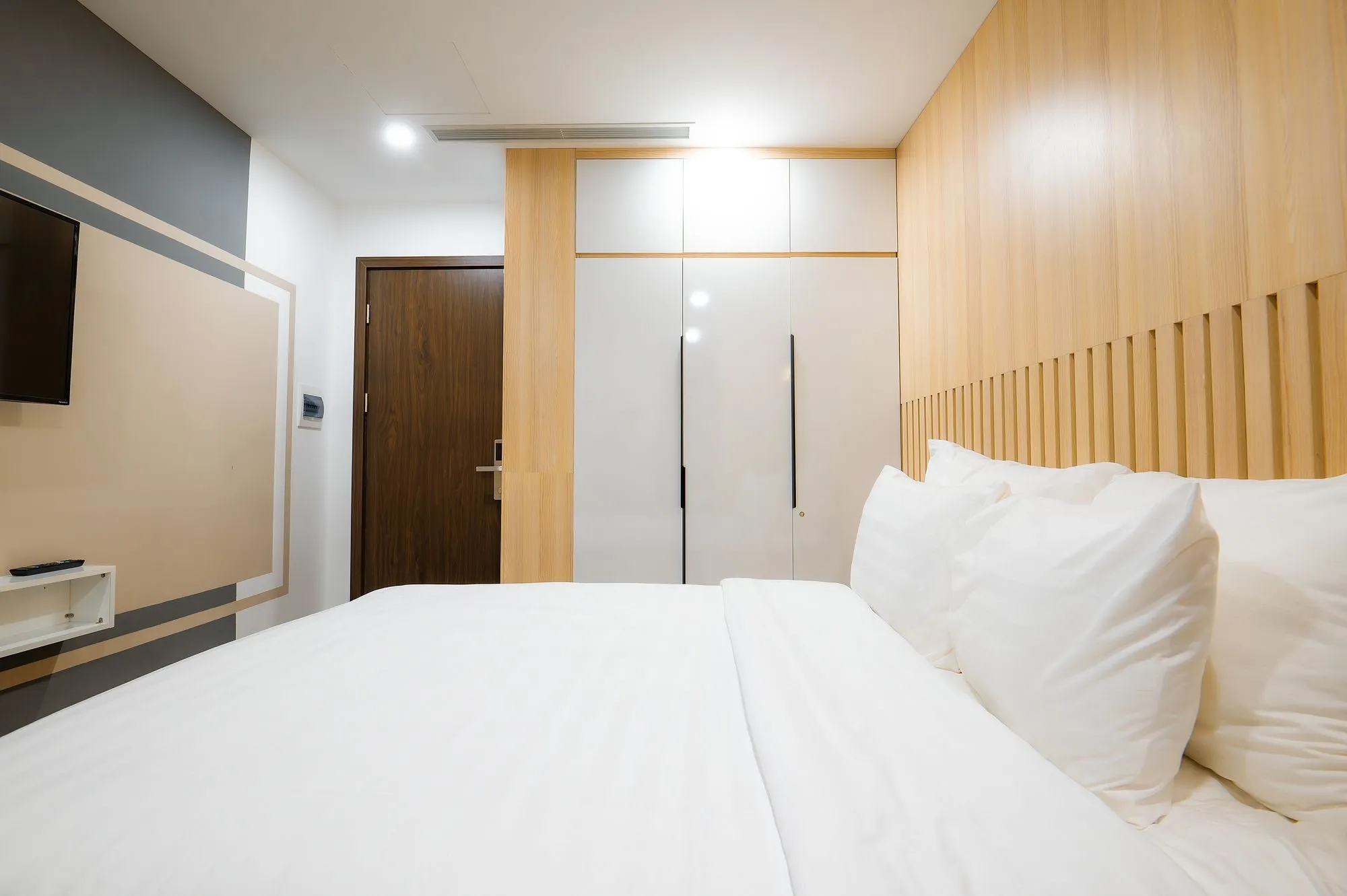 A finished bedroom with a smooth floor and built-in timber furniture