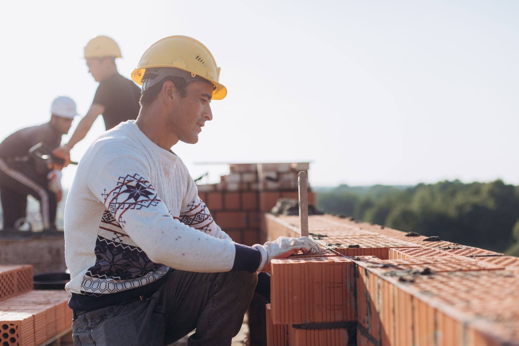 A builder laying brickwork on site