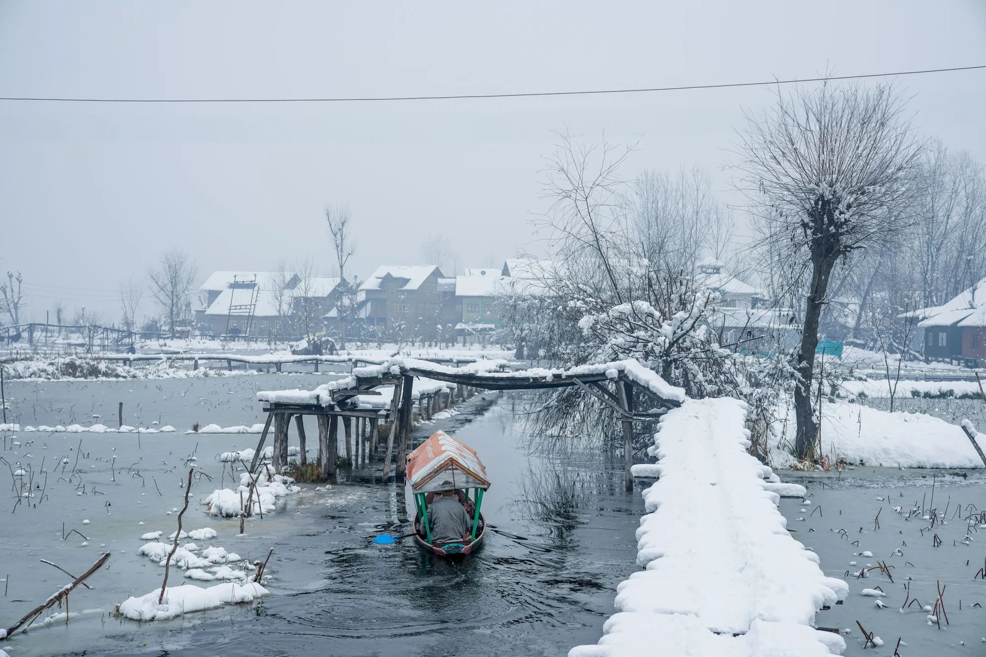 A waterfront structure and access path surrounded by heavy snow