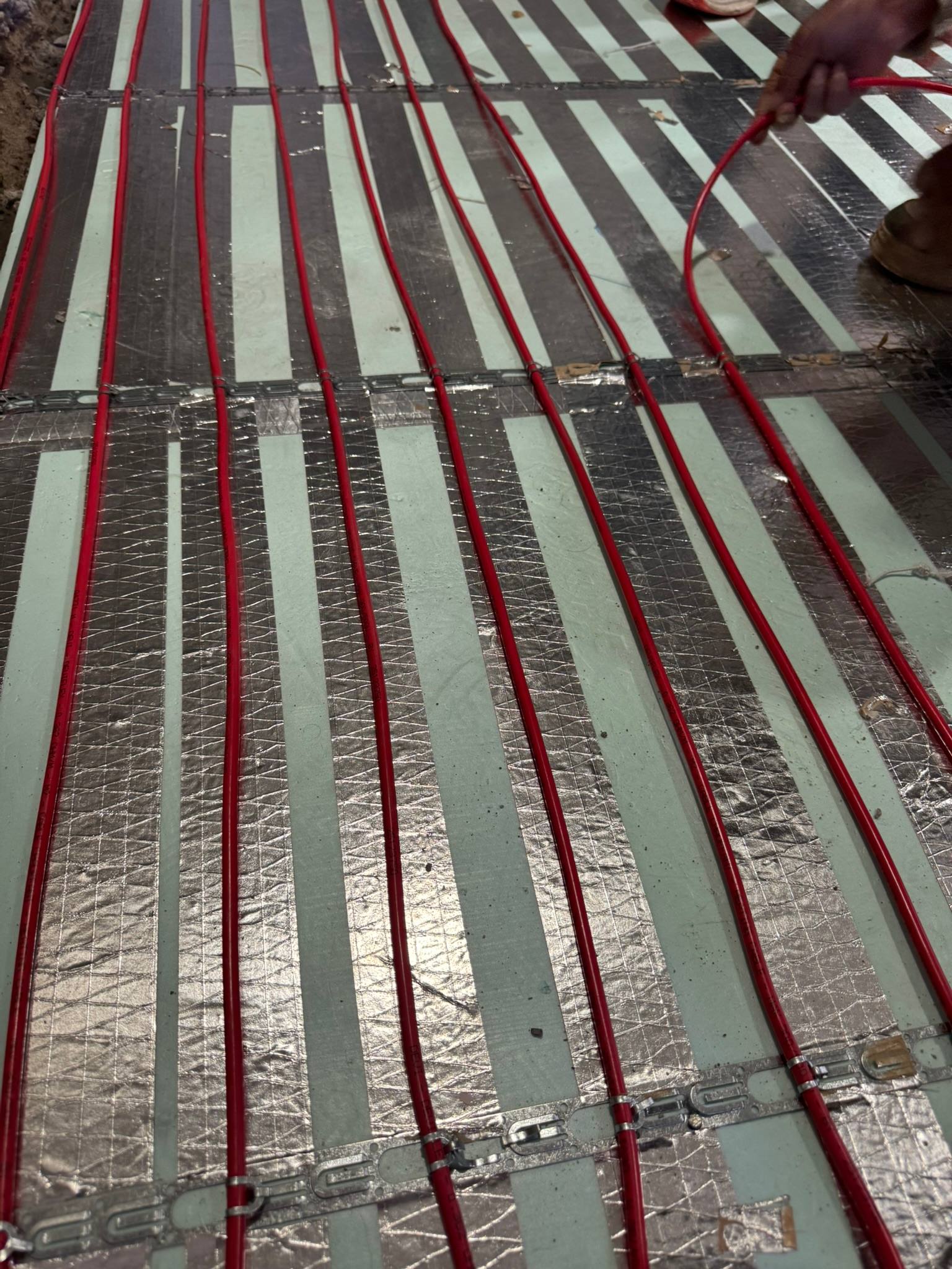 Electric hamam cables being installed over insulated floor backing by our site team
