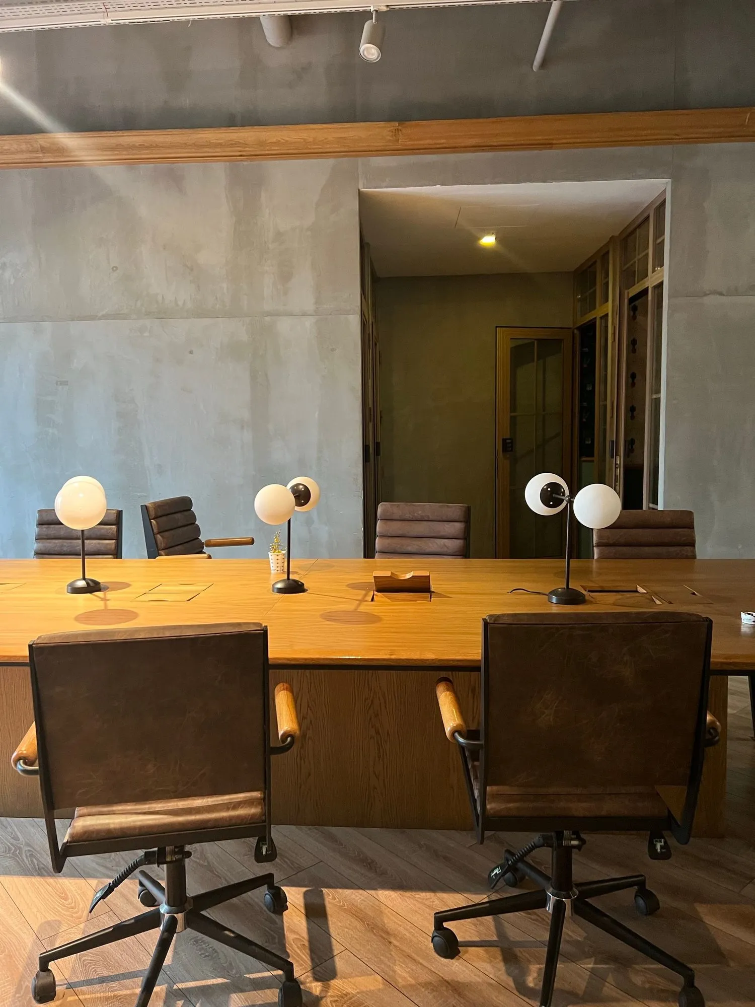 An interior meeting room with a long table, chairs and wall finishes