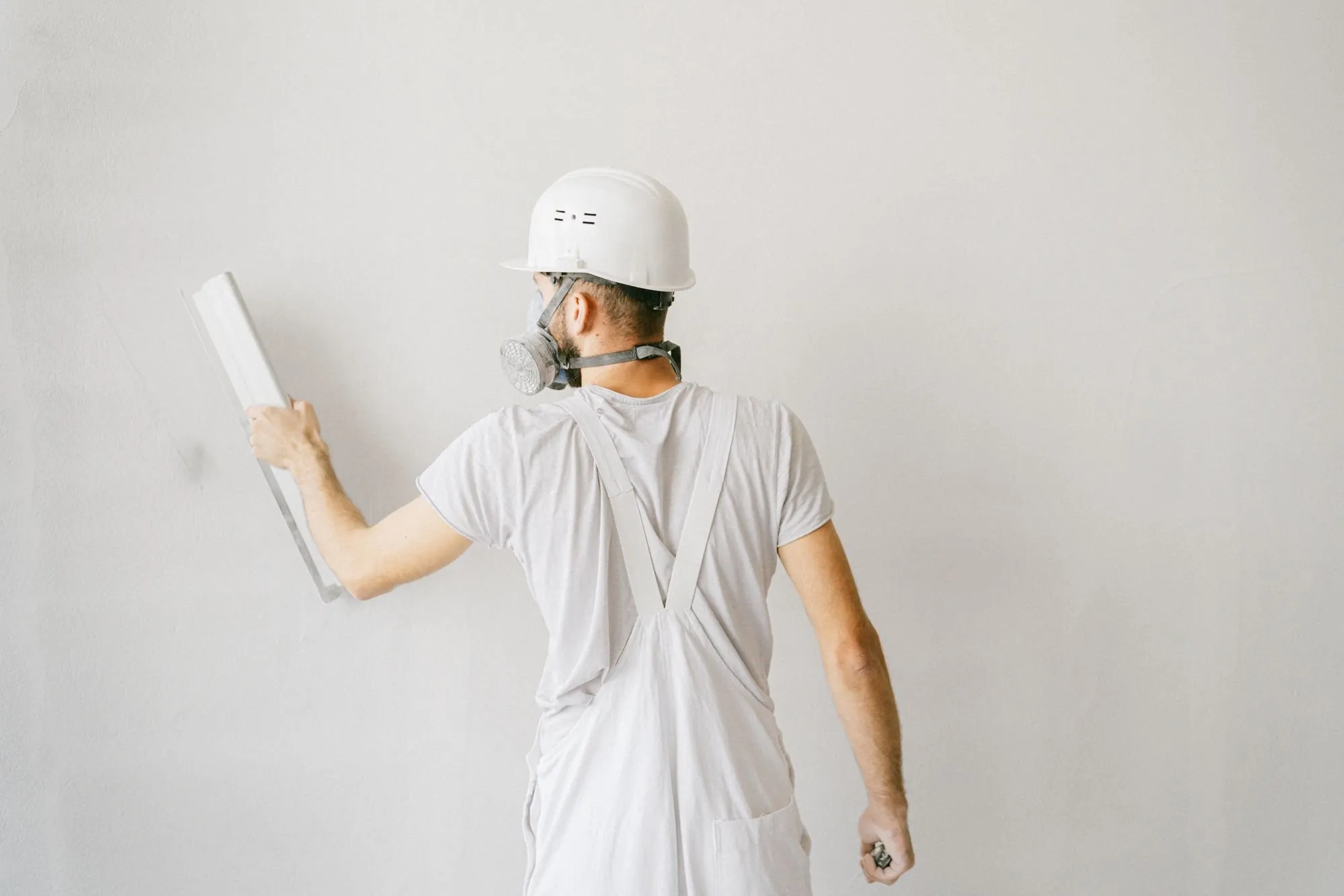A worker smoothing an internal wall with a finishing tool