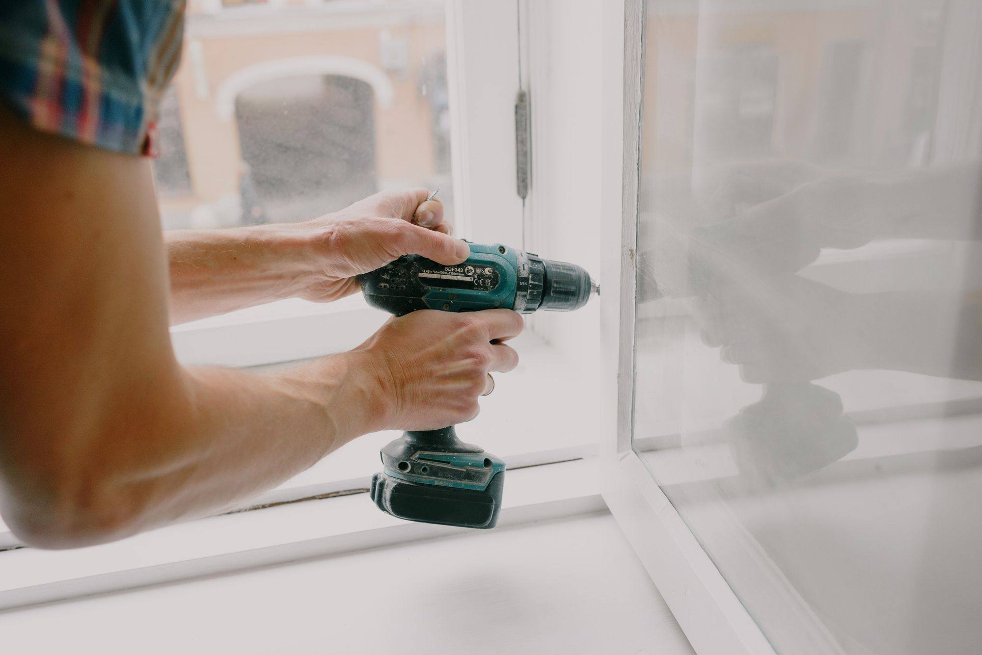 A drill being used to fit a window frame