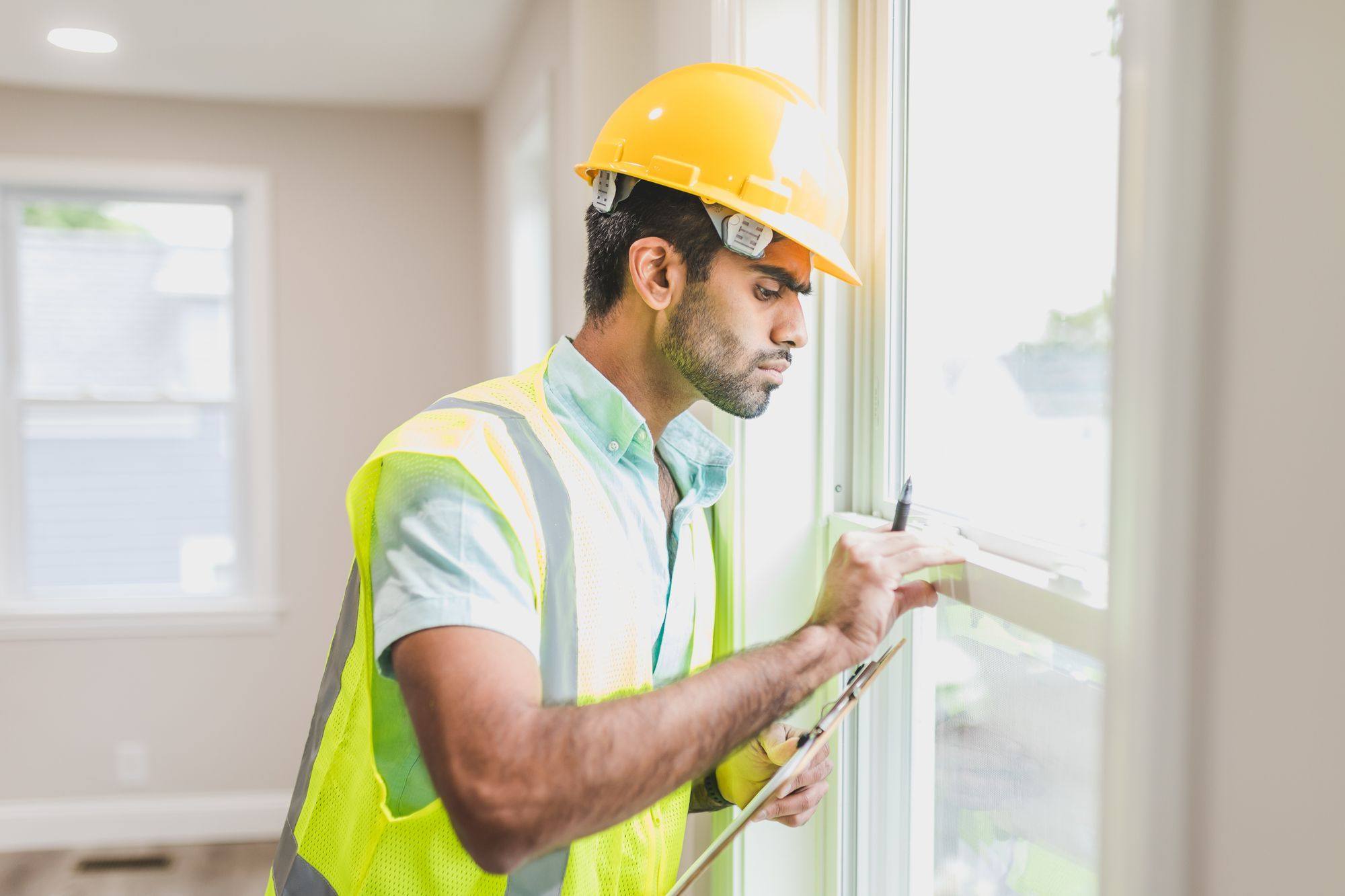 A worker examining the frame and joint around a window opening
